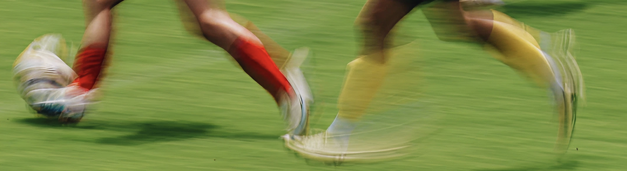 Girls running on football field in motion blur